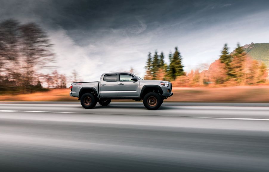 A Toyota Tacoma driving down a scenic highway, photographed in motion