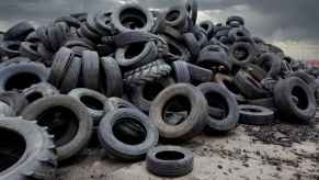 A large amount of discarded tires in the dirt