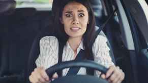 A woman driver with worried expression