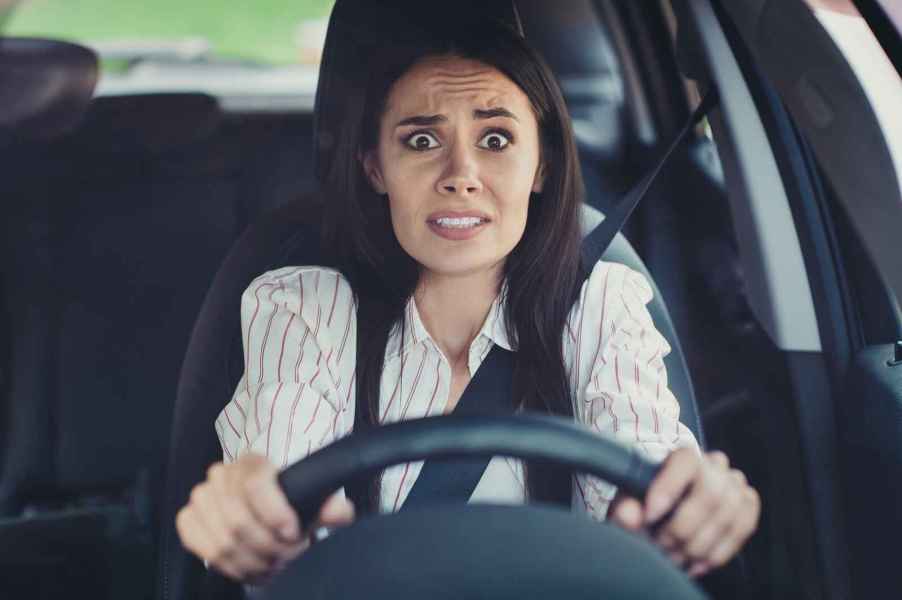 A woman driver with worried expression