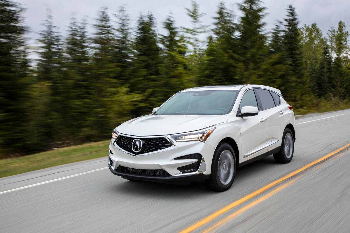 A white 2021 Acura RDX driving in left front angle view