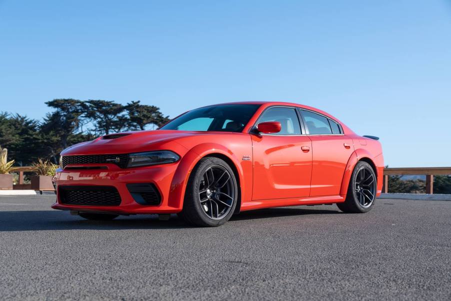 A red 2021 Dodge Charger Scat Pack Widebody parked on pavement in left front angle view
