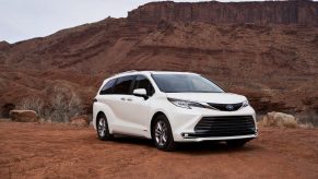 A white 2021 Toyota Sienna parked in right front angle view in a rocky, dusty clay desert environment