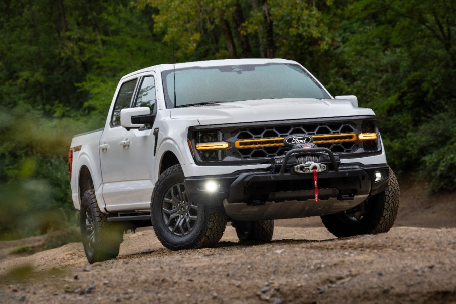 A white 2024 Ford F-150 Tremor parked on a dirt surface in right front angle view