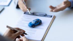 An agent and consumer talk about car insurance rates at a desk.