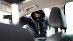 An armed criminal about to carjack a vehicle owner.