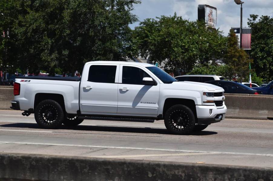 A white Chevy Silverado on a highway.