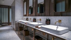 The interior of a luxury hotel bathroom with a marble/granite countertop and sinks.