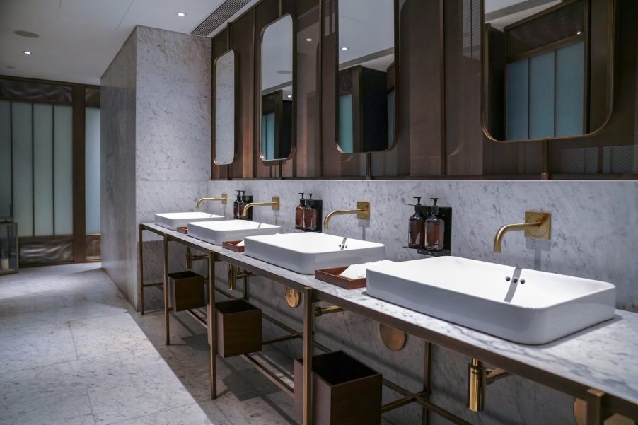 The interior of a luxury hotel bathroom with a marble/granite countertop and sinks.