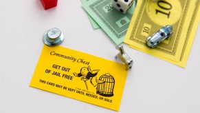 Bright yellow monopoly car in front of monopoly tokens and money
