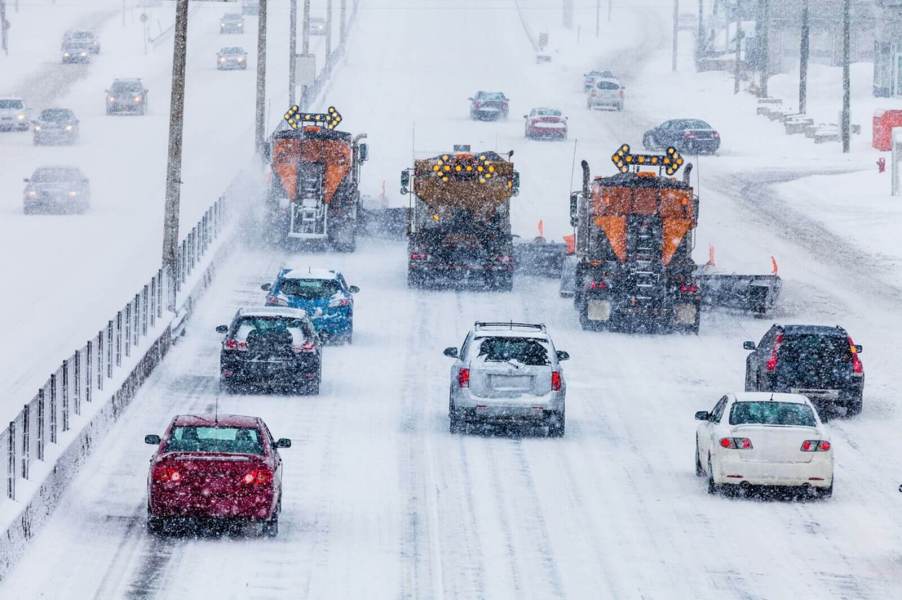 Drivers battle a winter storm on a highway.