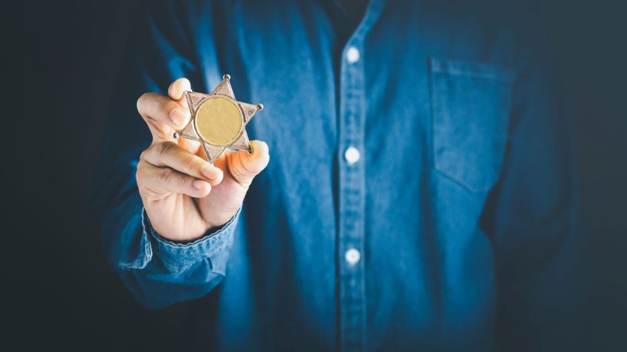 A man holding up a police badge