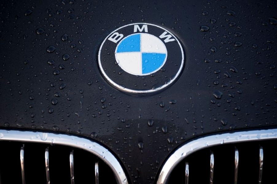 A BMW logo above the grille accentuated by rain on the black hood