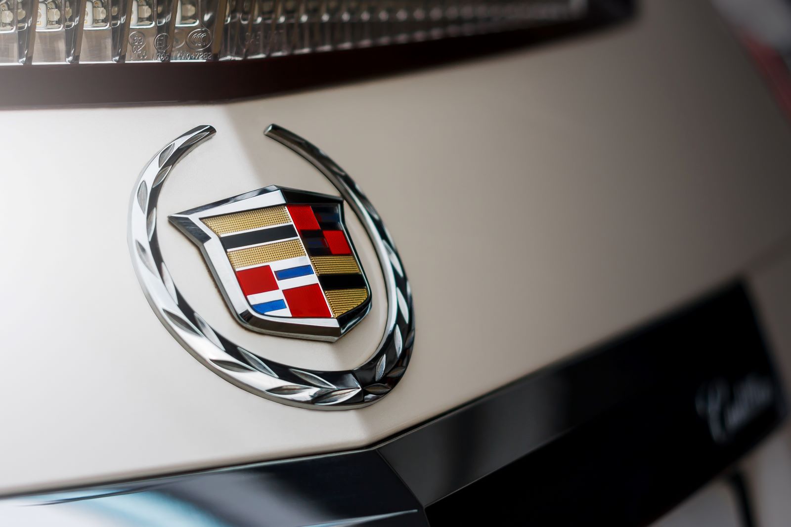 Cadillac emblem on an off-white car