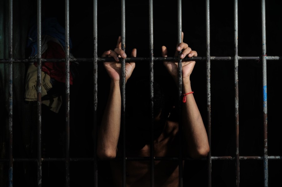 the hands of a driver on prison bars