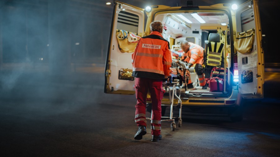 Paramedics loading an injured person into an ambulance