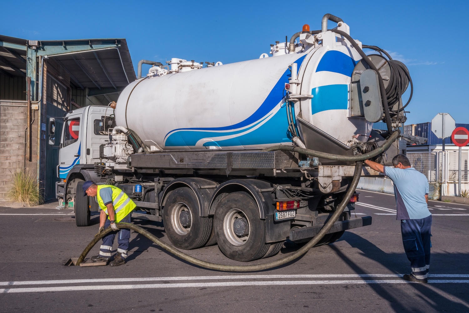 workers pumping with a sewage truck 