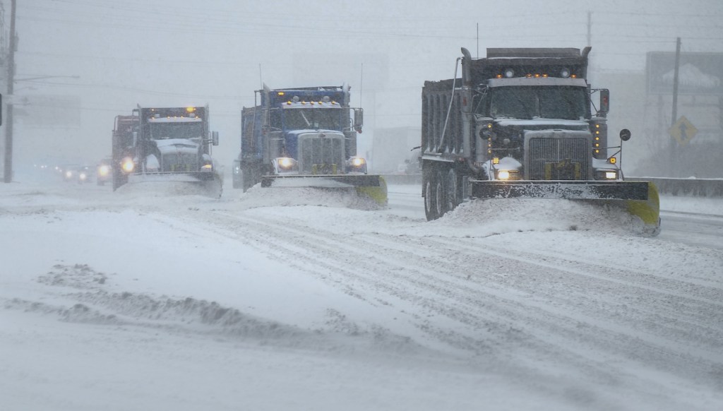 Snowplows clearing the road in a blizzard