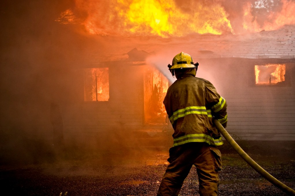 A firefighter using a hose to put out a fire