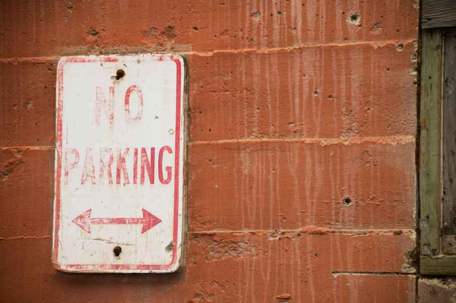 A sign on a brick wall that reads, "No Parking."