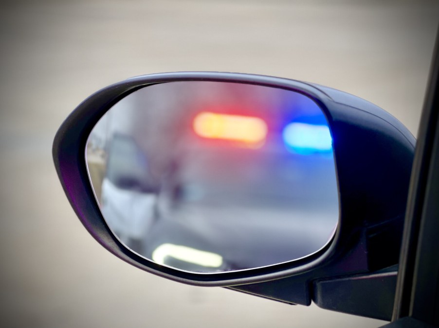 The view of a traffic stop taking place from driver's side mirror view