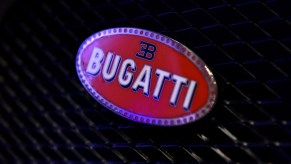 The red "Bugatti" badge on the grille of a supercar.