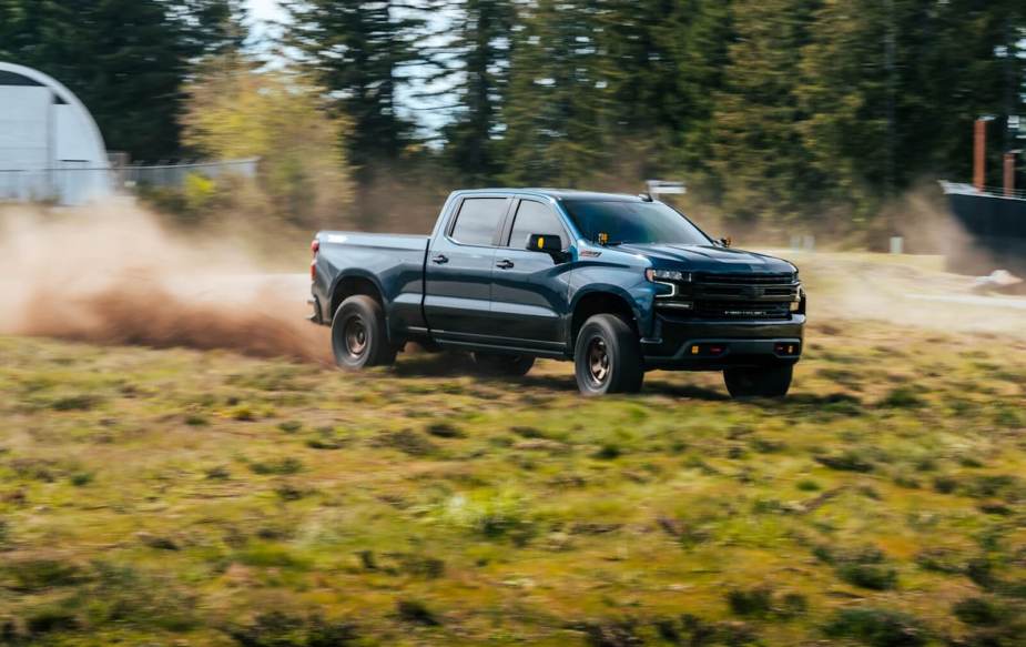 A Chevrolet Silverado pickup truck kicks up dirt and dust.