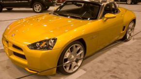 Yellow Dodge convertible sports car at an auto show.