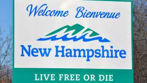 White and green "Welcome to New Hampshire" road sign.
