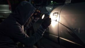 A person trying to break into and steal a car
