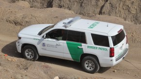 A Customs and Border Protection SUV on a dirt road