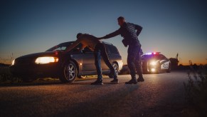 A police officer arresting a man at dusk