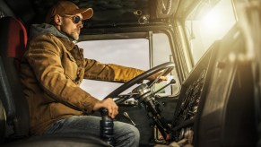 A semi-truck driver in his cab
