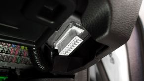 A car's OBD2 port under the dashboard