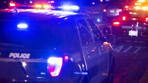 Police cruisers in close view at night with lights on