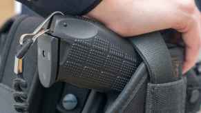 A policeman's hand on the butt of a taser gun