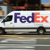 A speeding FedEx van on city streets.
