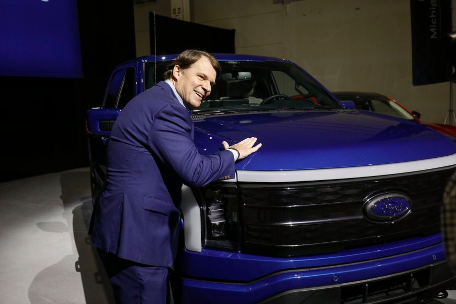 Ford CEO Jim Farley touching an F-150 Lightning EV.
