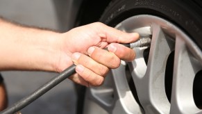The hand of Jonathan Chapa of Tennessee inflating his car tire during a police chase.