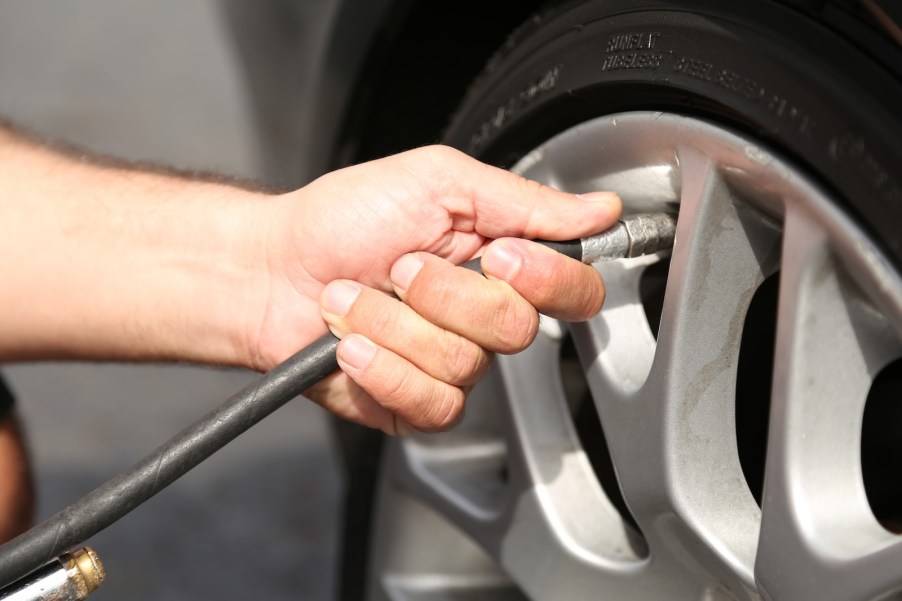 The hand of Jonathan Chapa of Tennessee inflating his car tire during a police chase.