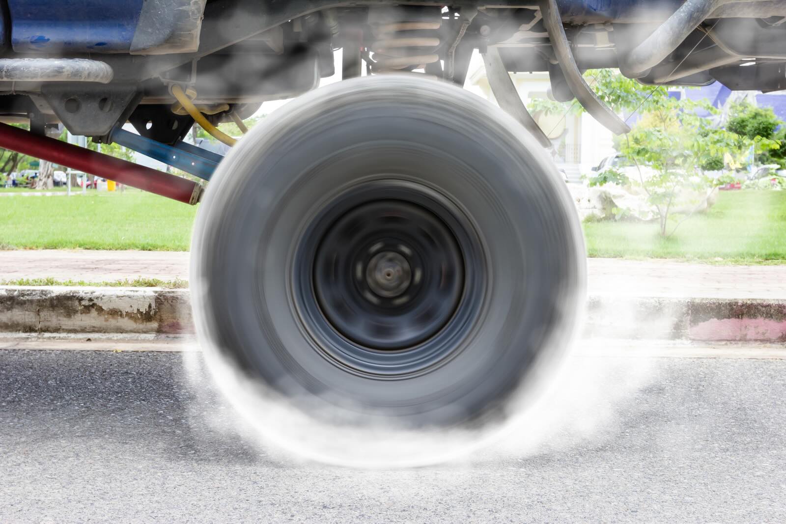 Tires of a Jeep Wrangler with a Viper V10 engine doing burnouts, trees visible in the background.