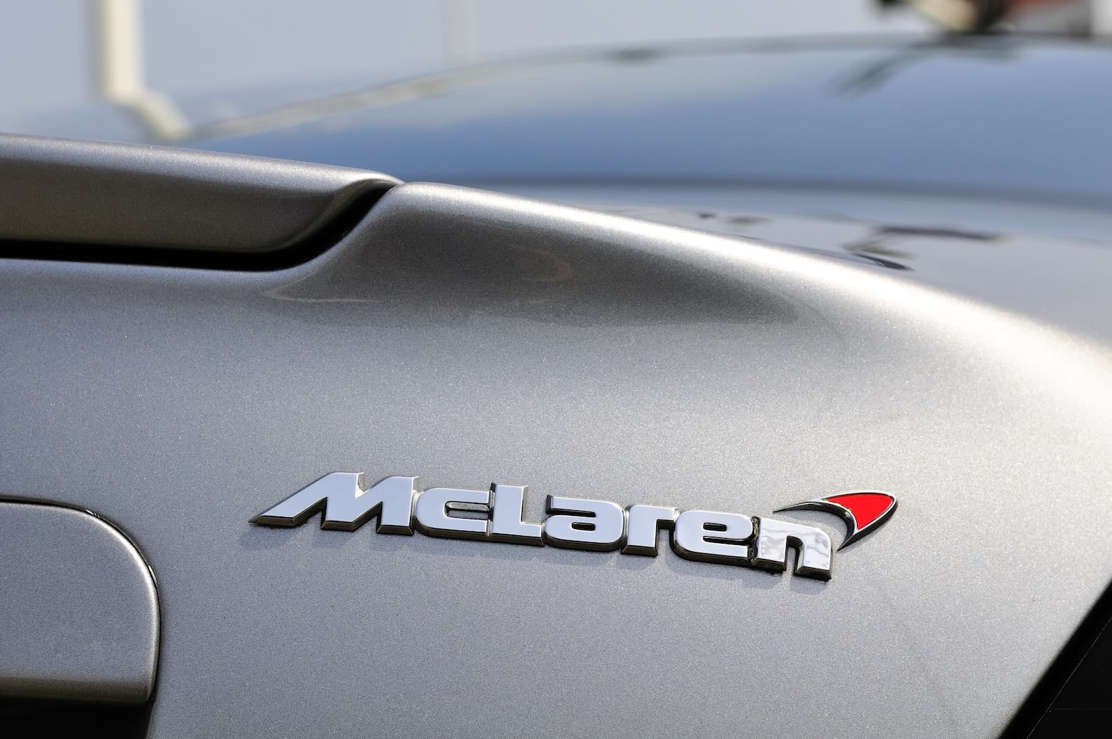 McLaren badge on a silver sports car, soon to be on an SUV