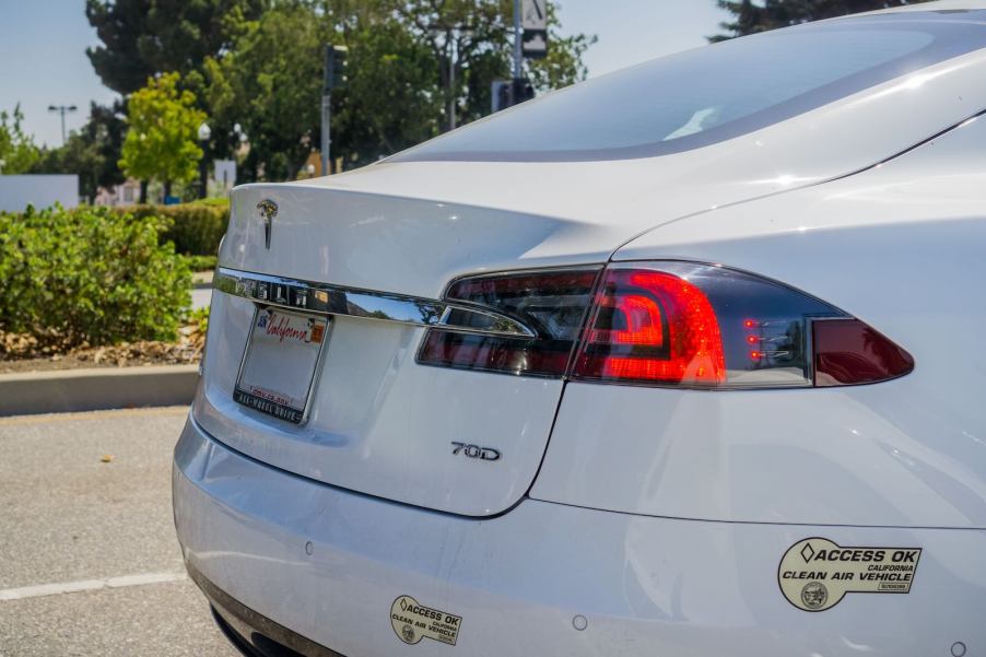 Tesla Model S EV with California plates and access ok bumper decal.