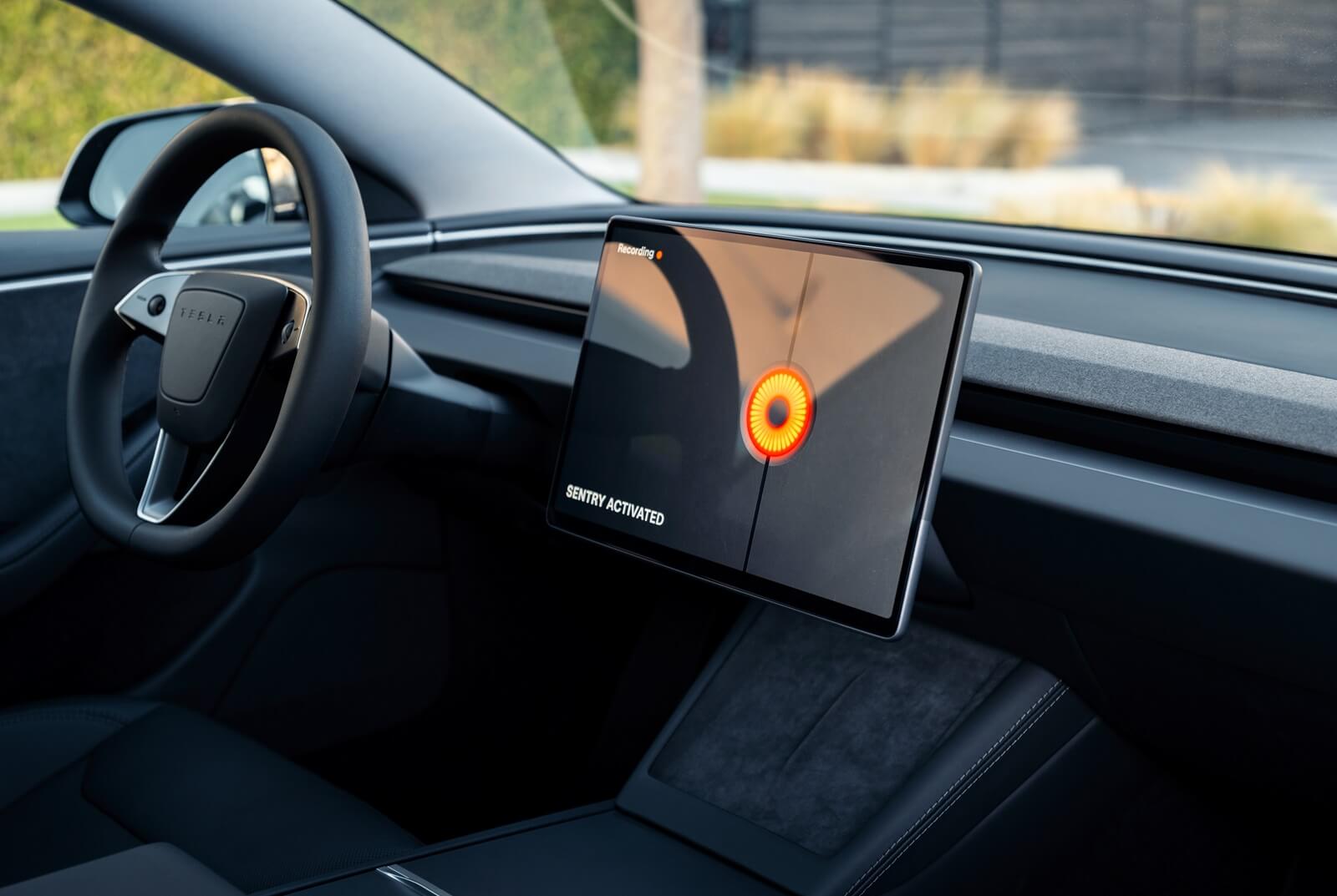 A Tesla Model 3 with Sentry Mode on its center screen.