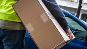 Amazon driver carries package in close rear view