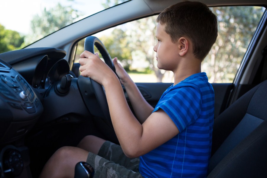 A little boy driving an SUV