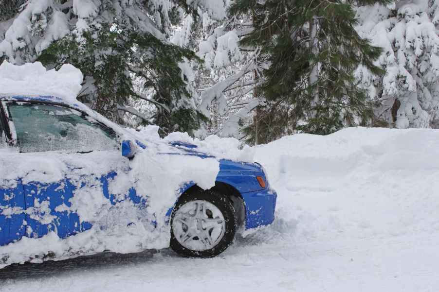 A blue 2002 Subaru Impreza being driven on a snowy road