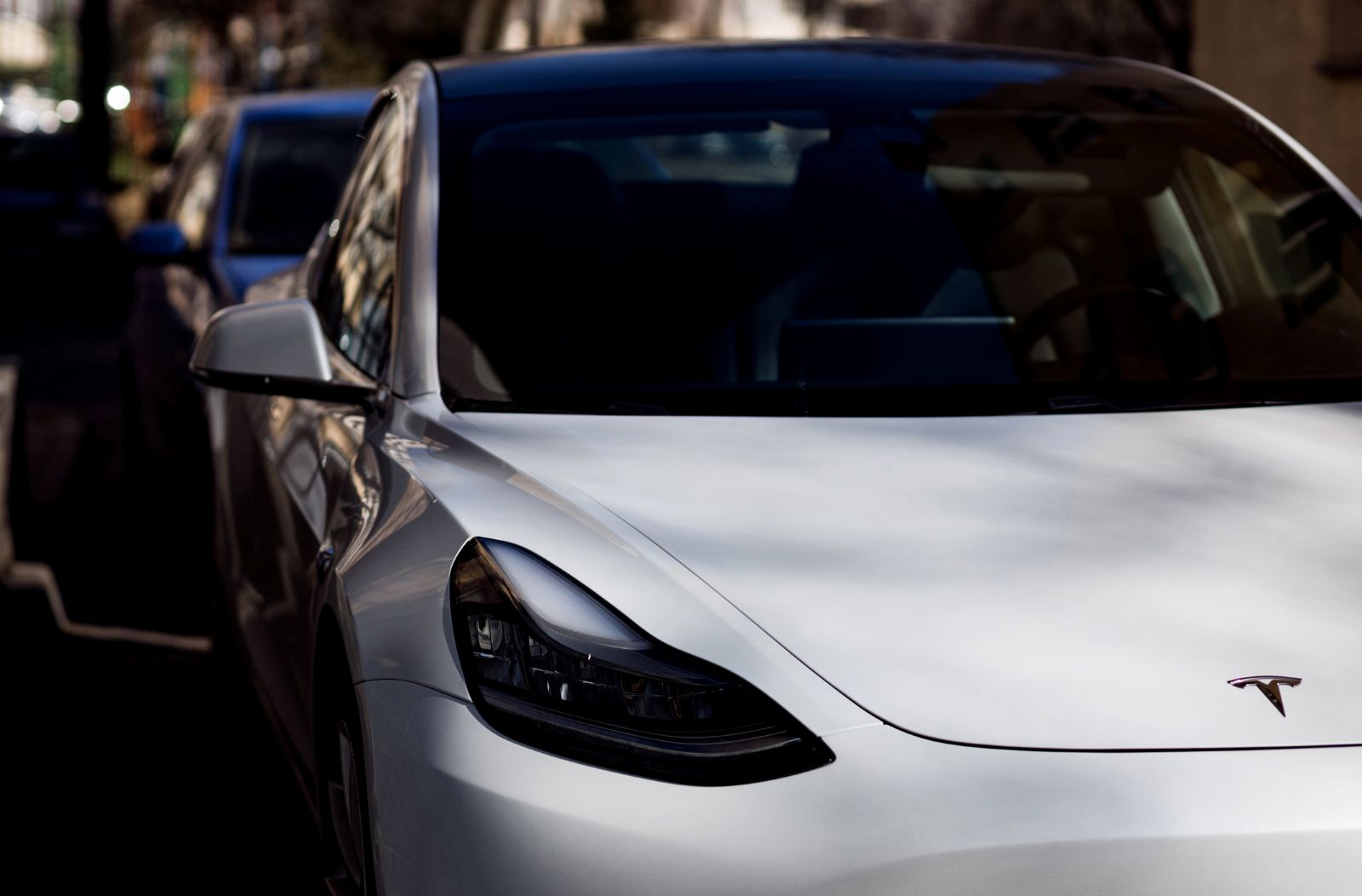 The front end of a Tesla model 3, highlighting the front of the EV