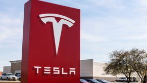 A large red sign reading, "Tesla" at a dealership