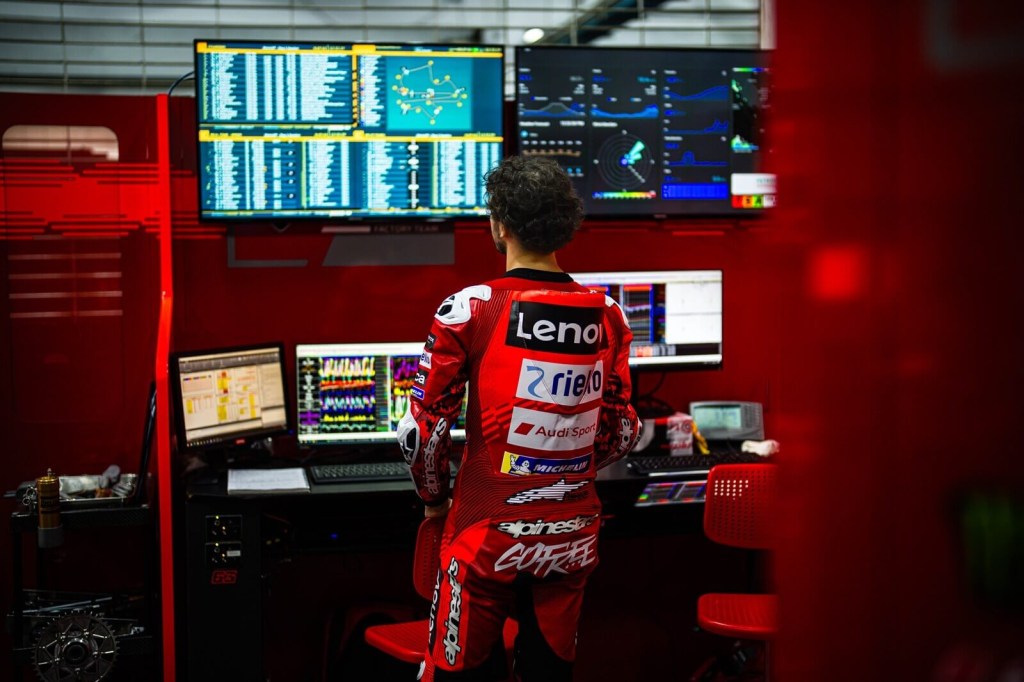 Francesco "Pecco" Bagnaia looks at screens with data and information from a practice run.